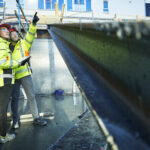 Kvinne og mann i synlighetstøy på byggeplass