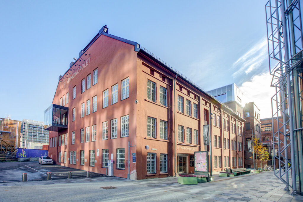 Bygate, gammelt mursteins,bygg i 3-4 etasjer. Blå himmel